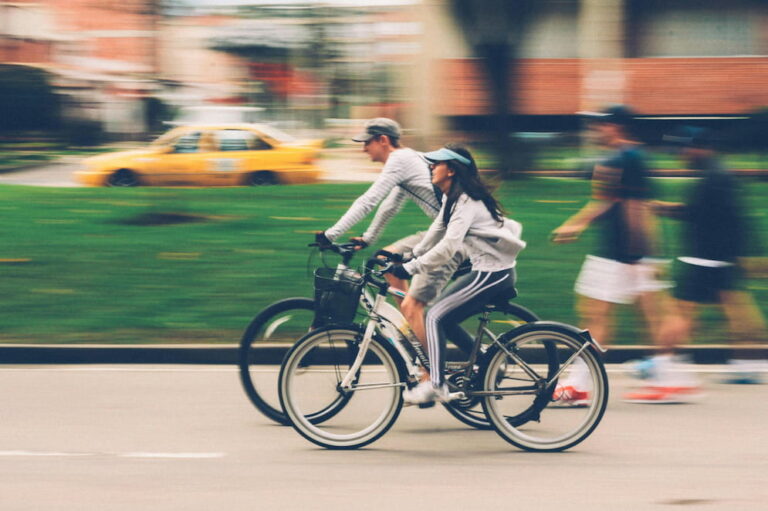 Two people exercising on bikes in a city
